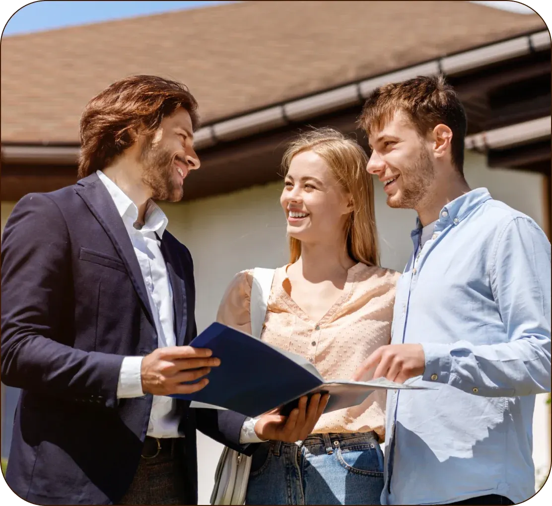 An agent going over the paperwork with a couple outside a house